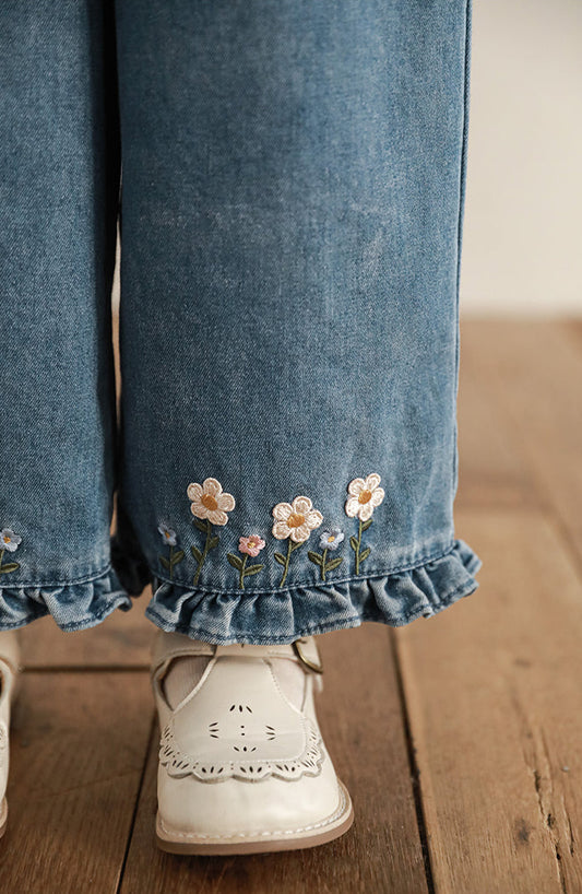 Close-up of floral embroidery on girls wide-leg ruffle jeans